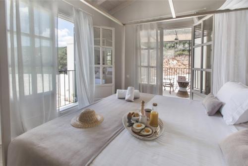 een witte kamer met een dienblad met eten op een bed bij Korypho Villas in Barbati