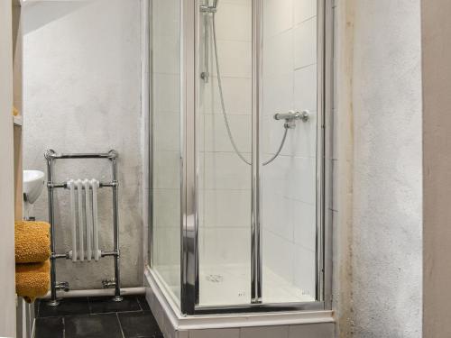 a shower with a glass door in a bathroom at The Old Barn in Saint Day