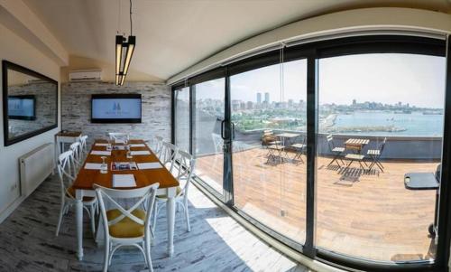 a dining room with a table and a large window at Melek Hotels Moda in Istanbul