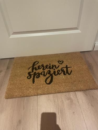 una alfombra marrón con las palabras de Farmrett escritas en ella en Ferienwohnung Ostfriesenherz Emden en Emden