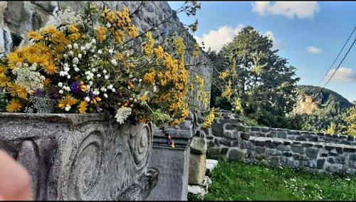 a stone wall with a bouquet of flowers on it at Vatra Strabunilor in Moigrad