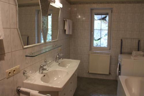 Baño blanco con lavabo y espejo en Appart Gabl, en Arzl im Pitztal