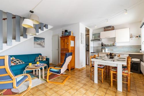 une cuisine et un salon avec une table et des chaises dans l'établissement À 50m de la plage, charmante maison à St Hilaire, à Plage-des-Demoiselles