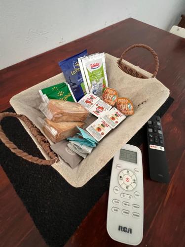 a basket of food and a remote control on a table at Excelente Ubicación con Patio y Parrilla Departamento Luminoso y con Desayuno in Junín