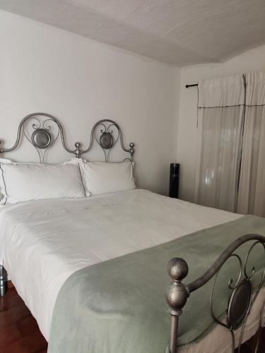 a bedroom with a large white bed with white pillows at Il Torrione del Trebbia in Bobbio