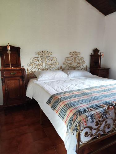 a bedroom with a bed and a wooden dresser at Il Torrione del Trebbia in Bobbio