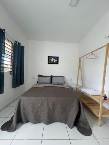 a bedroom with a bed in a white room at Mar de Gente Pousada in Praia de Moitas