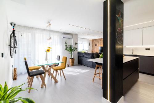 uma cozinha e sala de estar com mesa e cadeiras em Apartamento inteligente con vistas a la Alhambra em Granada