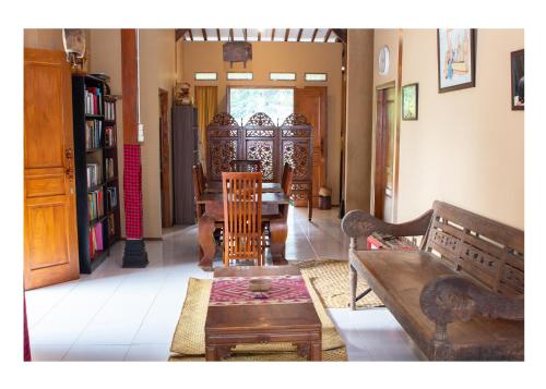ein Wohnzimmer mit Holzstühlen und einem Tisch in der Unterkunft Sanggar Pantcha Indra in Kemuning