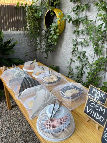 a picnic table with umbrellas and plates on it at Mar de Gente Pousada in Praia de Moitas