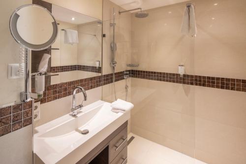 a bathroom with a sink and a shower and a mirror at Superior Hotel Post Ischgl in Ischgl