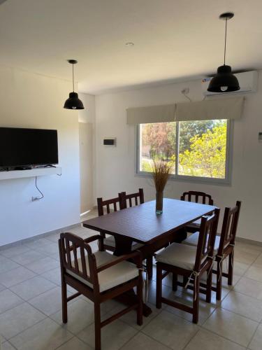 a dining room with a wooden table and chairs at Departamento Temporario La Quebrada in La Rioja