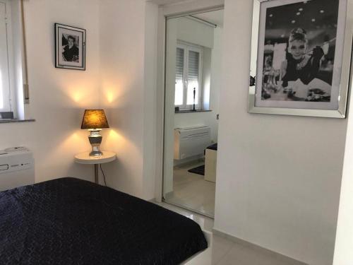アウグスタにあるVilla private Siracusa luxuryのベッドルーム(ベッド1台、鏡、ランプ付)
