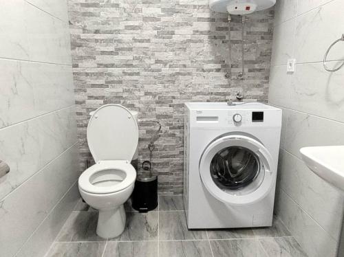 a bathroom with a toilet and a washing machine at Katerina's Apartment in Bitola