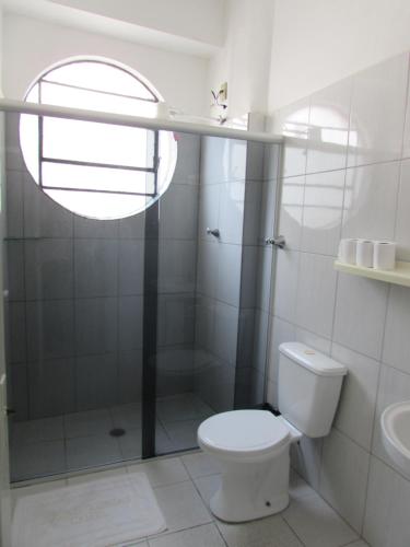 La salle de bains blanche est pourvue d'une douche et de toilettes. dans l'établissement Nébias Palace Hotel junto da Avenida Ipiranga com São João em Frente ao Bar Brahma SP, à São Paulo