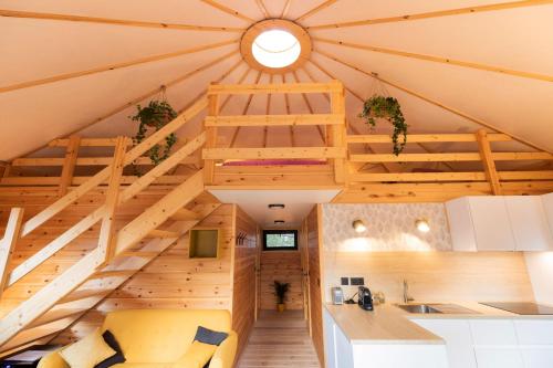 eine Küche im Dachgeschoss und ein Wohnzimmer mit einer großen Holzdecke in der Unterkunft Le Scandin'Havre in Hannut