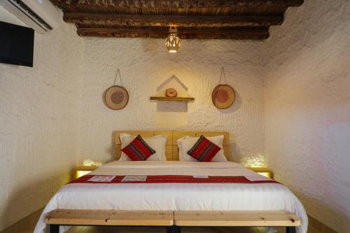 a bedroom with a large bed with red and white pillows at Sama al Wasil Desert Camp in Shāhiq