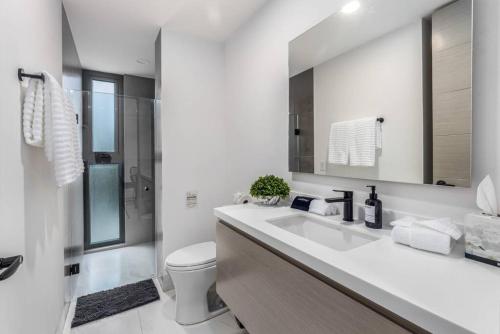 a white bathroom with a sink and a toilet at Endless Summer - 2Bed 2Bath Condo - Seasonly Heated Pool with Ocean Views - 5min walk to Beach - Fibre Internet - Sleeps 6 in Cabo San Lucas