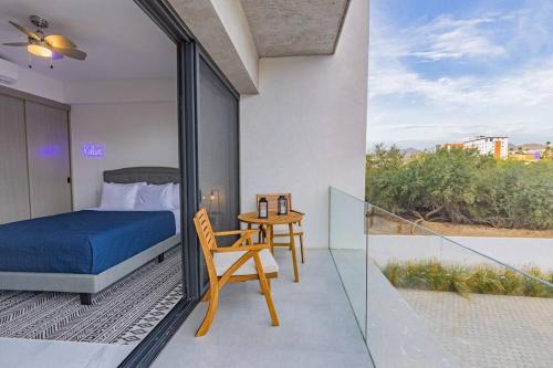 a bedroom with a bed and a table with a chair at Endless Summer - 2Bed 2Bath Condo - Seasonly Heated Pool with Ocean Views - 5min walk to Beach - Fibre Internet - Sleeps 6 in Cabo San Lucas