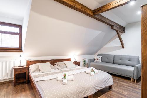 ein Schlafzimmer mit einem großen Bett und einem Sofa in der Unterkunft Apartmány in Veritas in Mikulov