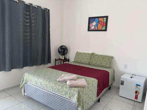 a bedroom with a bed and a black curtain at Mar de Gente Pousada in Praia de Moitas