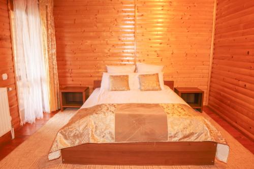 a bedroom with a bed in a wooden cabin at Erney Laz Hotel in Shaian