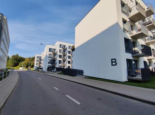 an empty street next to a white building at Apartments Franny's Bees in Vilnius