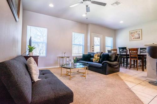 a living room with a couch and a table at Belair Lux 3BR 3BA Home W Private Hot tub, 3k Arcade Games & private garage- 5mins to the Airport in San Antonio