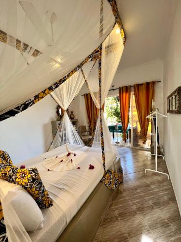 a bedroom with a bed with a canopy at Gadea Boutique Hotel& Gadea Garden Italian Restaurant in Jambiani