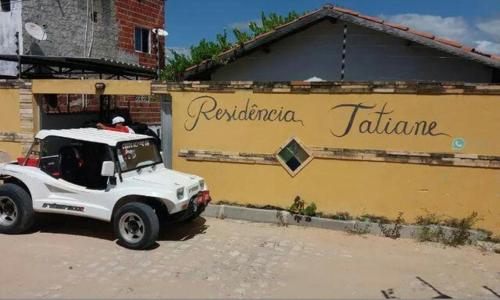 um camião branco estacionado em frente a um edifício em Chalés Residência Tatiane em Canoa Quebrada