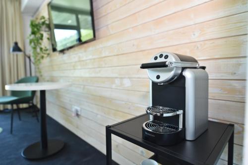 a coffee maker sitting on a table in a room at Pensiunea Atra Doftana in Teşila