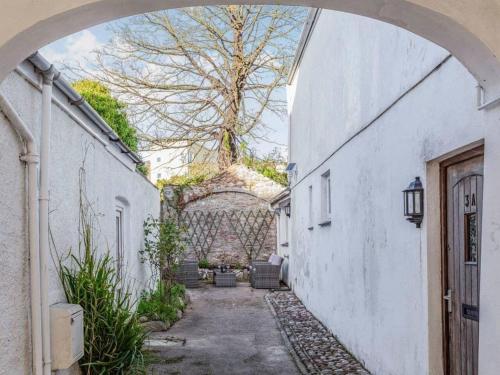 an alley with an archway between two white buildings at Lovely Villa 1 double 1 double sofa 6 single 1bunk in Torquay