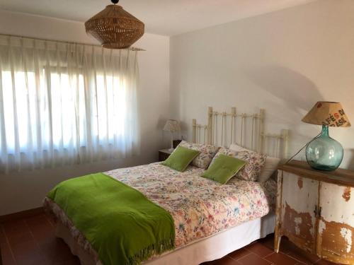 a bedroom with a bed with two green pillows at Apartamentos Montemar in Navia