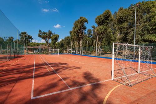 a tennis court with a net on top of it at Paradù EcoVillage & Resort in Marina di Castagneto Carducci