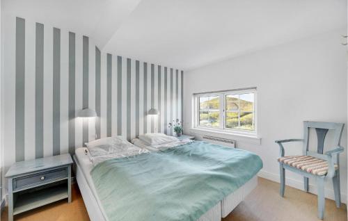 a bedroom with a bed and a chair and a window at Beautiful Apartment In Ringkbing With Sauna in Søndervig