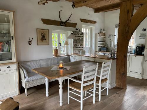 uma cozinha com uma mesa e cadeiras e um sofá em Fachwerkhaus am See mit privat Strand em Warendorf