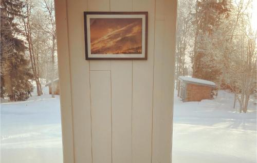 a picture hanging on the side of a house in the snow at Åreskutans Fjällstuga in Huså