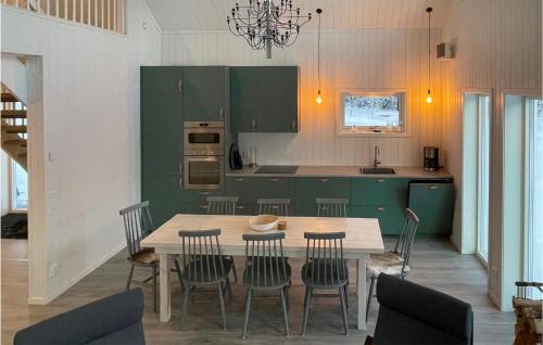 a kitchen with green cabinets and a table and chairs at Åreskutans Fjällstuga in Huså