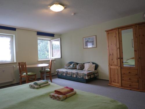 a bedroom with two beds and a table and a couch at Ferienwohnung am Markt in Bad Muskau