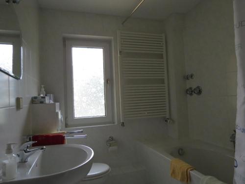 ein Badezimmer mit einem Waschbecken, einer Badewanne und einem WC in der Unterkunft Ferienwohnung am Markt in Bad Muskau