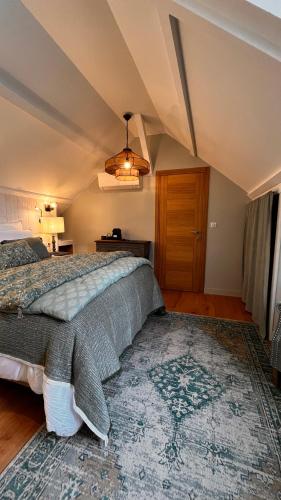 a bedroom with a large bed and a rug at La Plonploniere in Aix-en-Issart