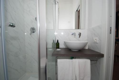 a white bathroom with a sink and a shower at Casa Di Mezzo by Arbaspàa in Manarola