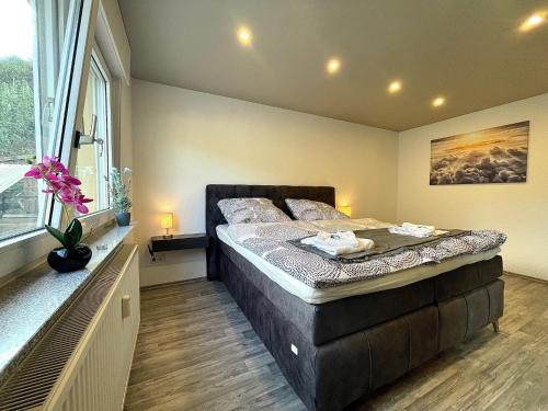 a bedroom with a large bed and a large window at Sweet Six, Sauna, Balkon, Netflix, Boxspringbetten, hochwertiges Bad in Zell an der Mosel