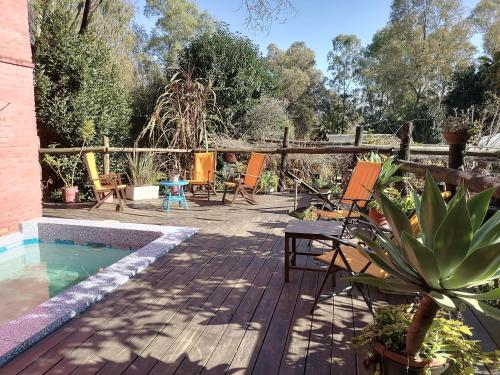 a deck with chairs and a swimming pool at La Estancia hostel in Colonia del Sacramento