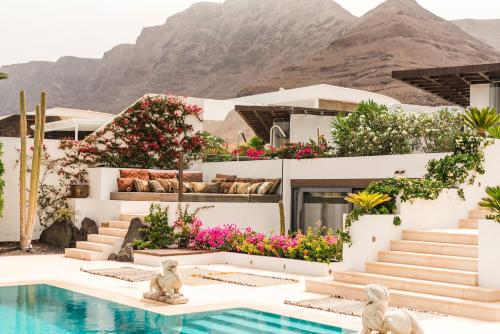 a resort with a pool and mountains in the background at Casa Sua in Famara