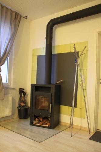 a fireplace in a living room with a stove at FEWO Steile WH 2 Wand 106 Meerane in Meerane