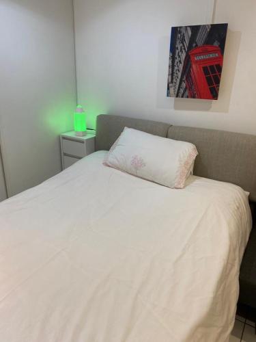 una camera da letto con un letto bianco e un cuscino sopra di Studio - Carré de Soie Vaulx en Velin a Vaulx-en-Velin