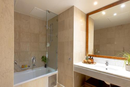 a bathroom with a tub and a sink at Giannoulis - Grand Bay Beach Resort (Exclusive Adults Only) in Kolymvari