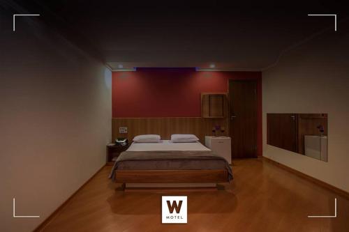 a bedroom with a large bed and a television at Wmotel in Ouro Branco