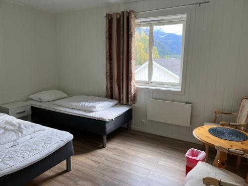 a bedroom with two beds and a window at Åndalsnes gustehouse in Åndalsnes